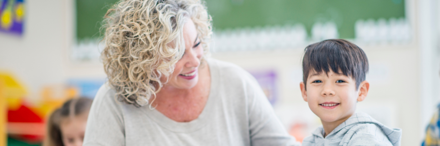 Happy teacher with young special educational needs pupil